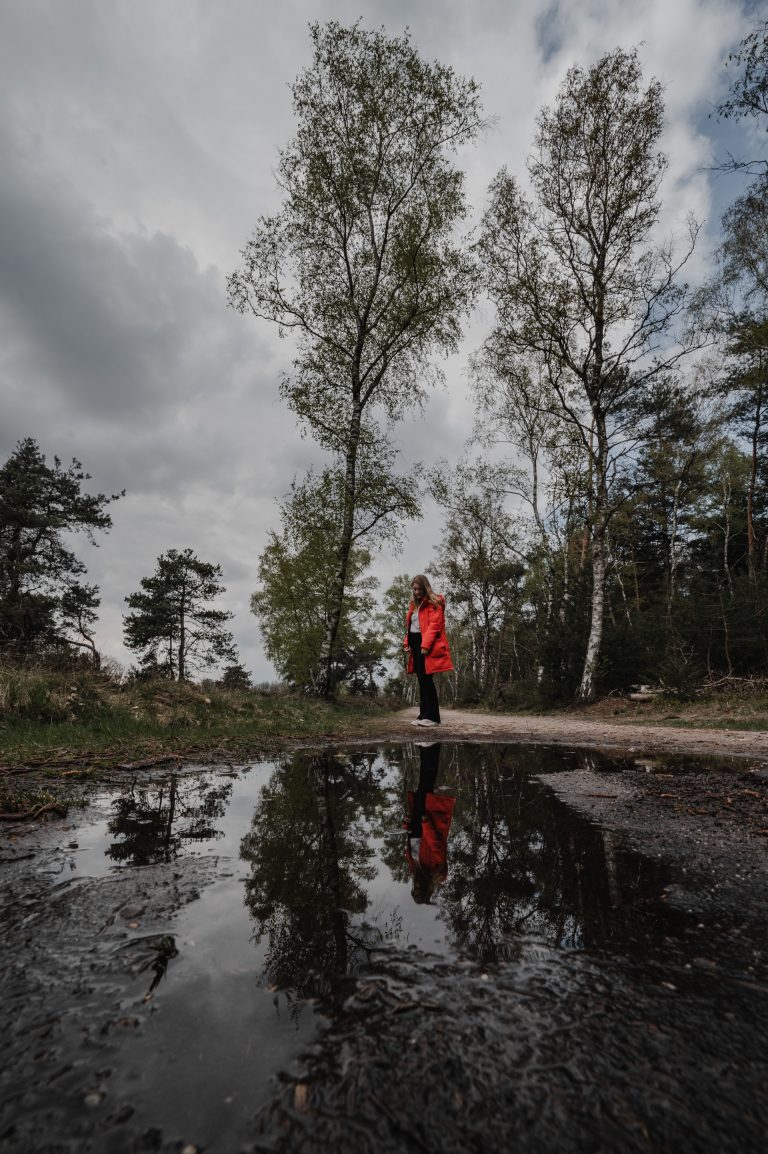 Vrouw in reflectie van het water in het bos